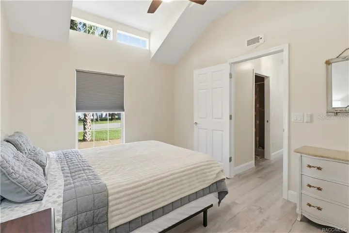 Bedroom – Comfortable bedroom featuring VAULTED CEILINGS, luxury vinyl plank flooring, ceiling fan, spacious double closets &amp; attractive furnishings.
