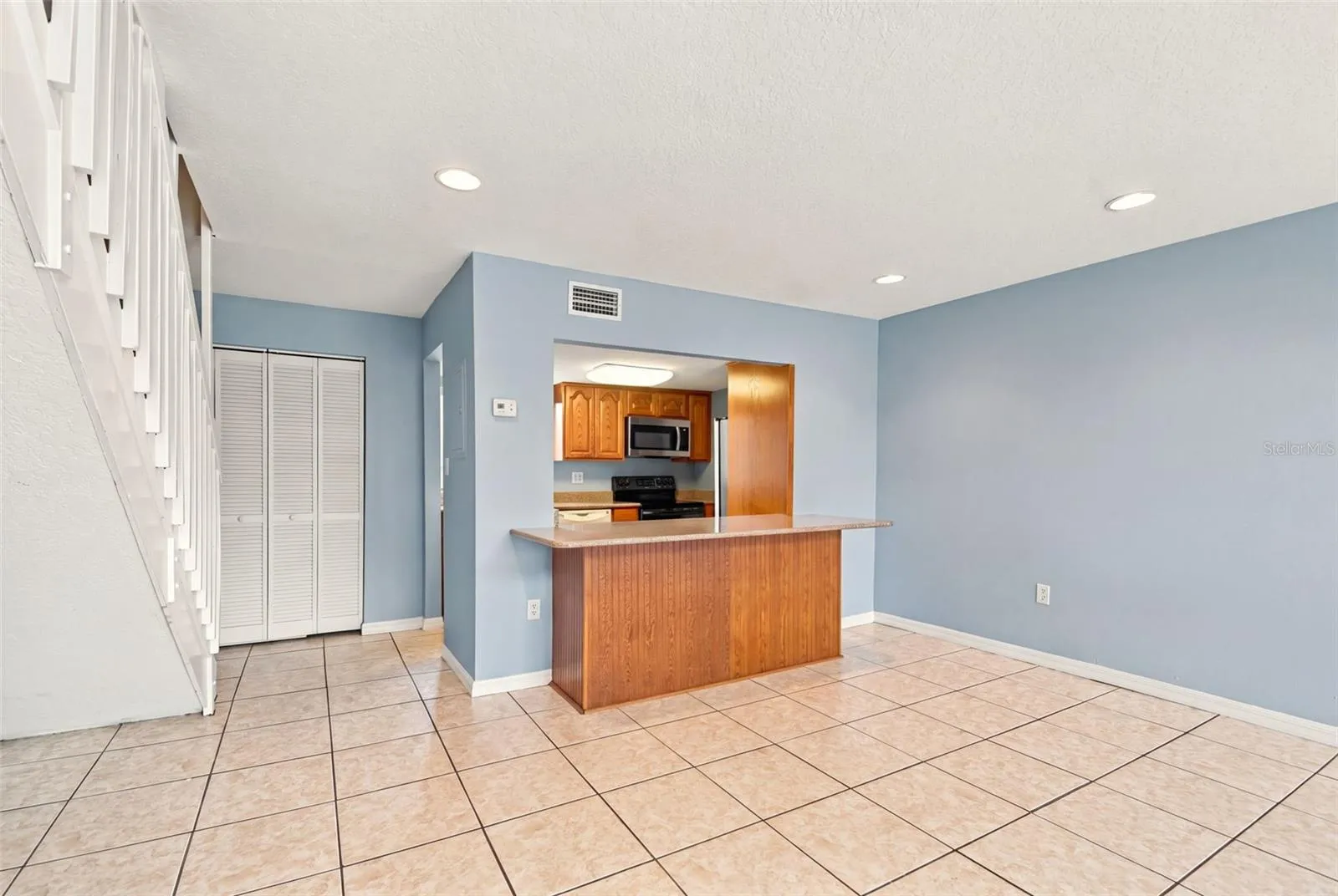Kitchen counter with stairs to loft on left