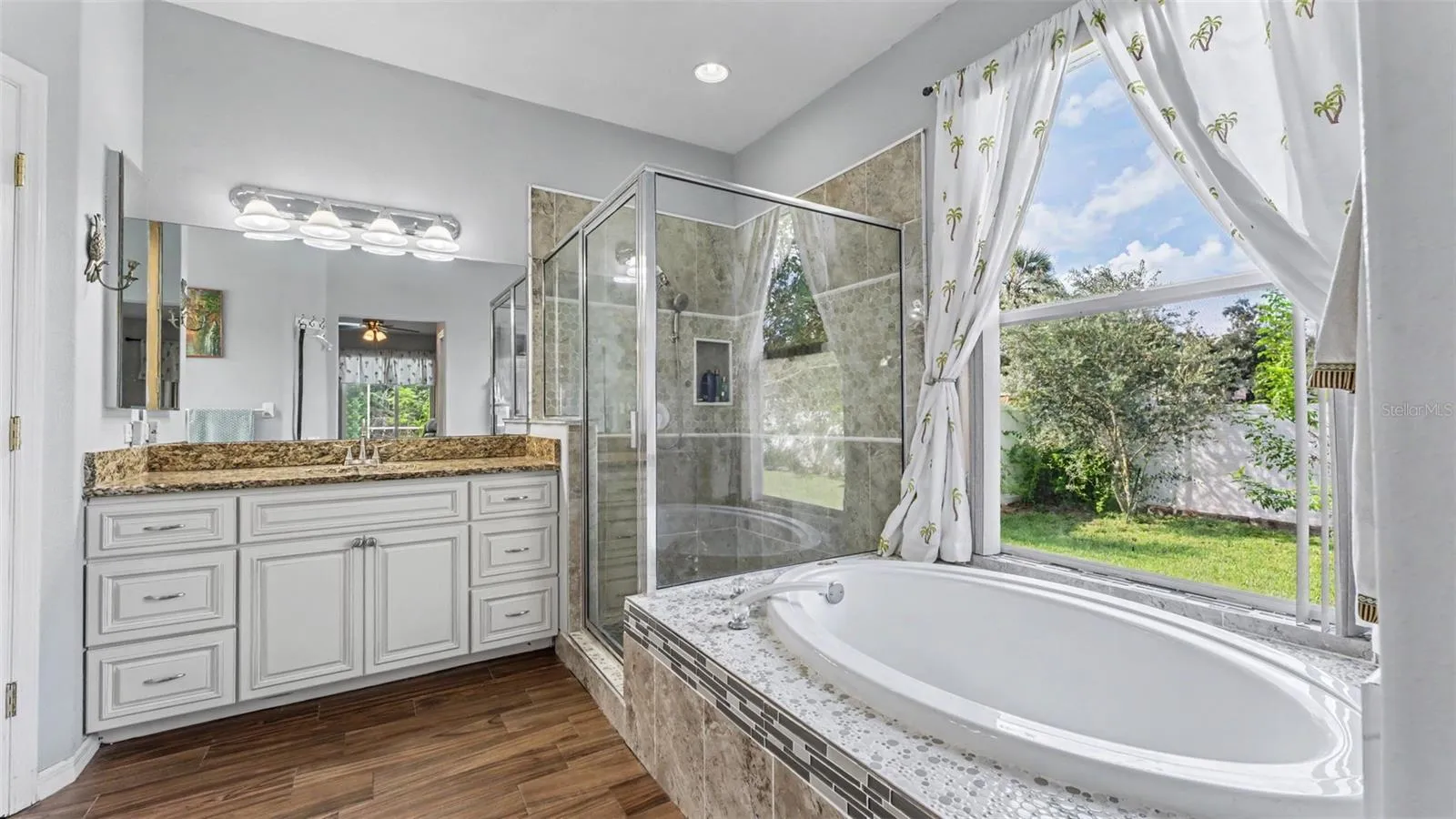 Beautiful remodeled ensuite bathroom with soaking tub, walk-in shower, double vanities, and private toilet room