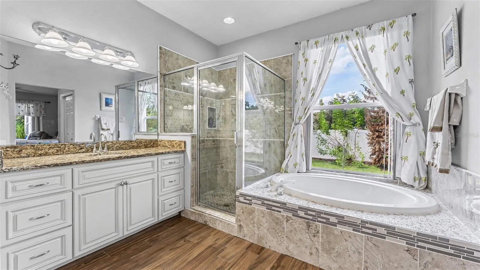 Beautiful remodeled ensuite bathroom with soaking tub, walk-in shower, double vanities, and private toilet room