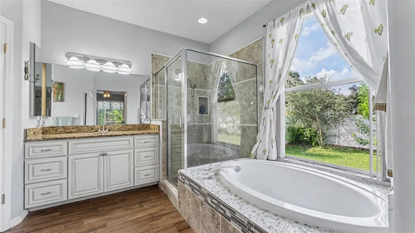 Beautiful remodeled ensuite bathroom with soaking tub, walk-in shower, double vanities, and private toilet room