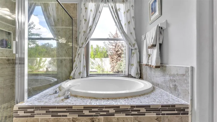 Beautiful remodeled ensuite bathroom with soaking tub, walk-in shower, double vanities, and private toilet room