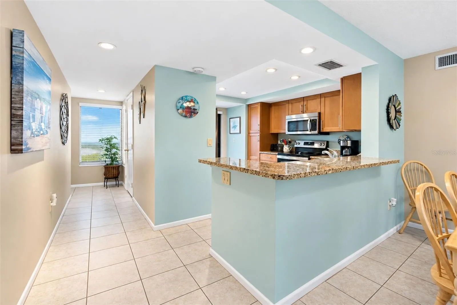 The kitchen features tiled flooring and a high top breakfast bar.