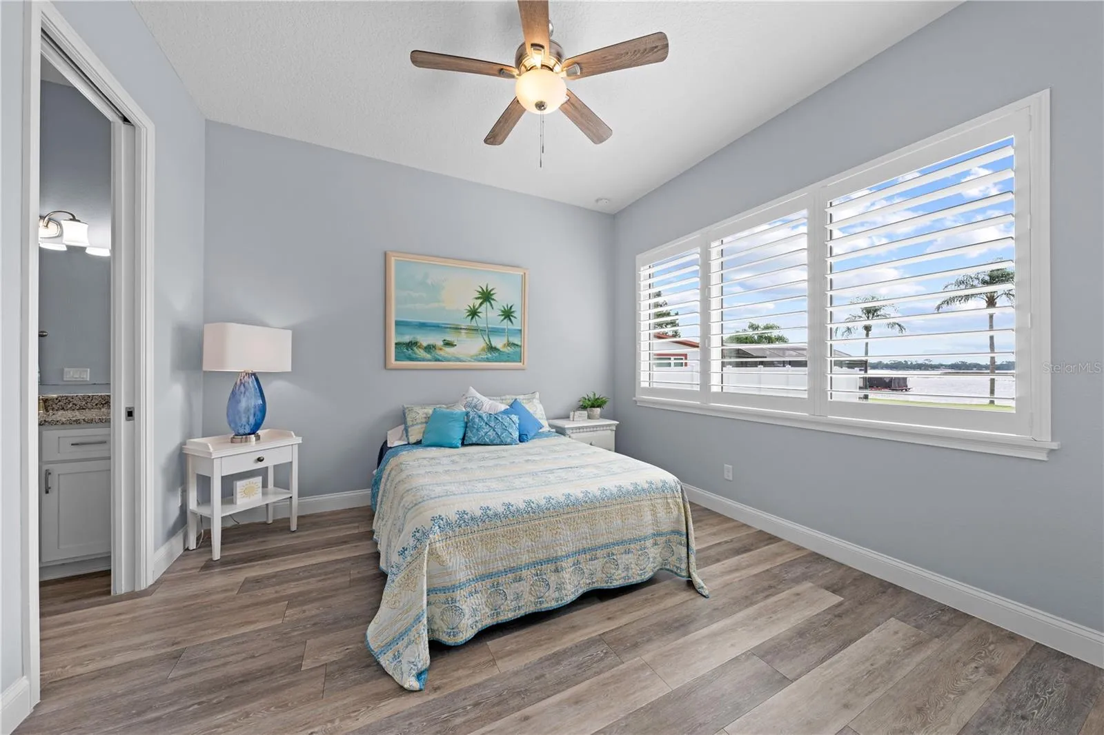 2nd primary bedroom with plantation shutters overlooking the lake