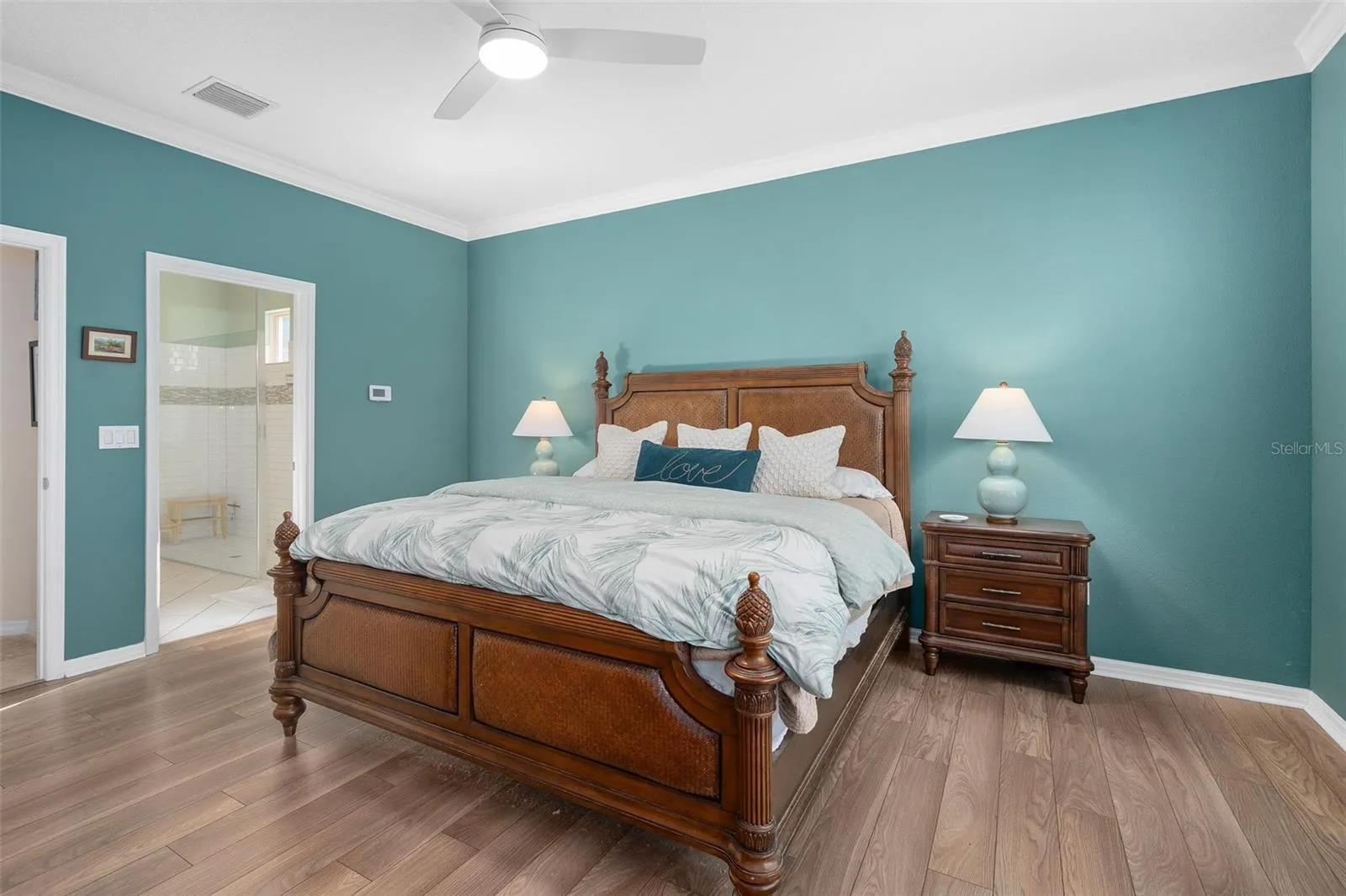 Primary Bedroom suite with Luxury Vinyl Plank Flooring Crown Molding with a view of the Primary En-Suite