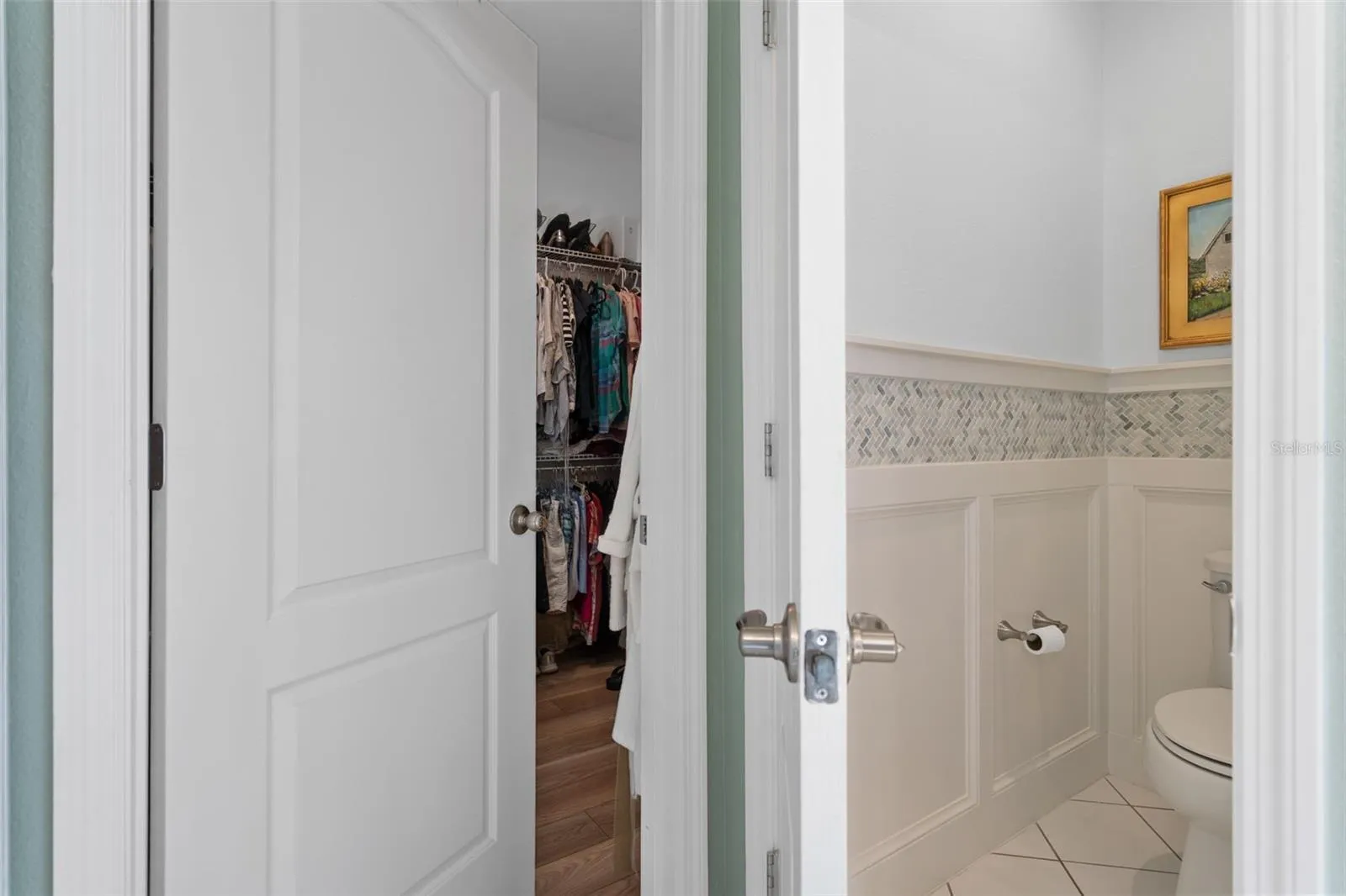 The Primary En-Suite Water Closet offers a Custom Wall Treatment. The walk-in Closet offers plenty of space and  LVP flooring.