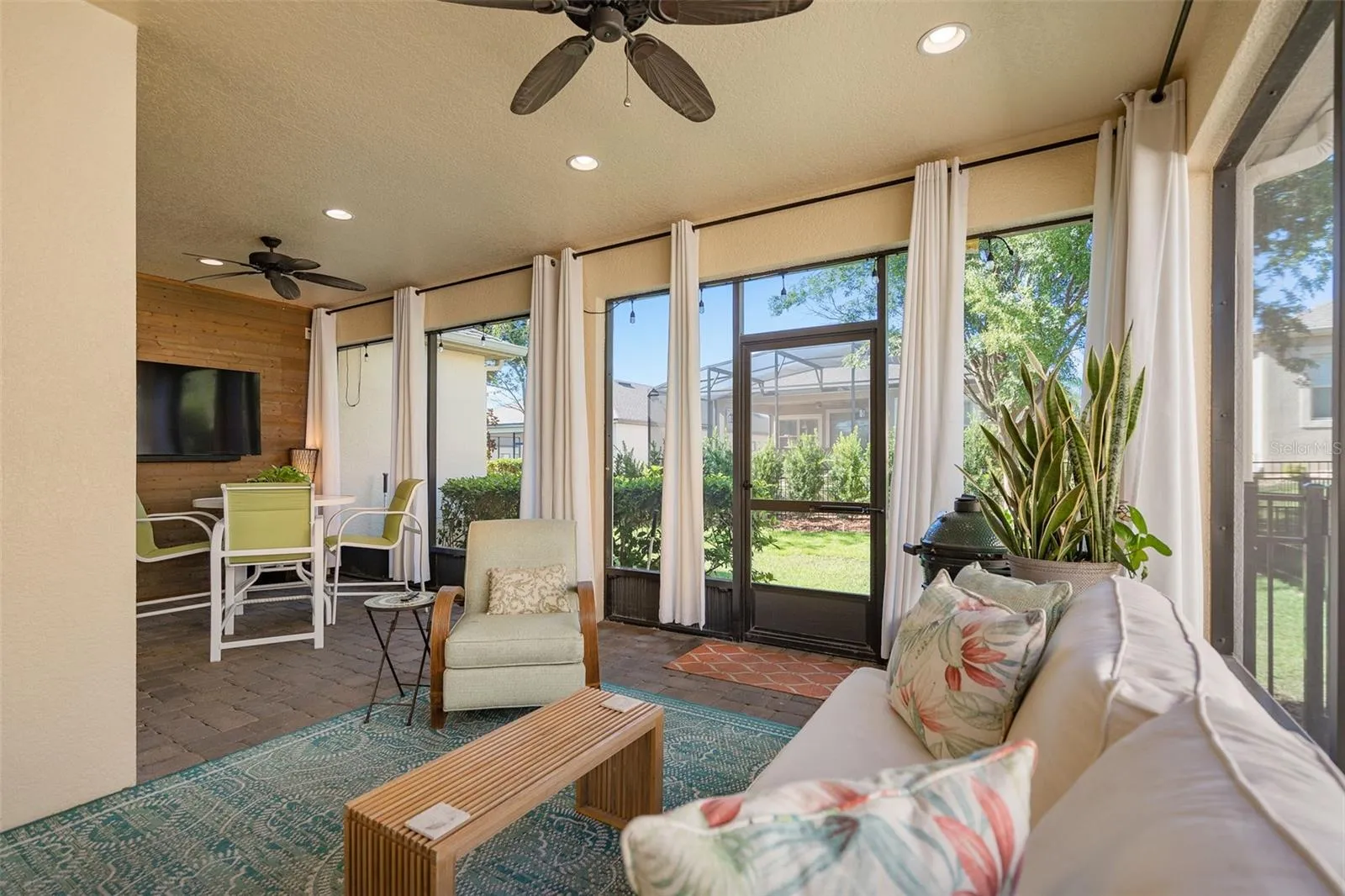 Enjoy the Screened Lanai with a Wood Accent Wall with TV connections, 2 Ceiling Fans and Pavers