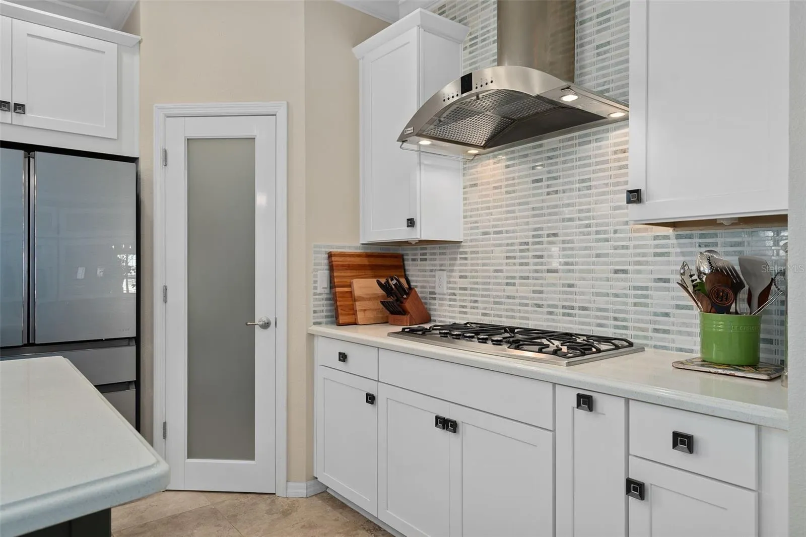 Corner Pantry with a Custom Frosted Glass Door. The Pantry has been outfitted with Custom Organization including a Lazy Susan.