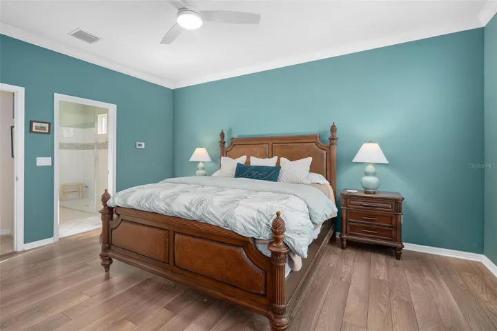 Primary Bedroom suite with Luxury Vinyl Plank Flooring Crown Molding with a view of the Primary En-Suite