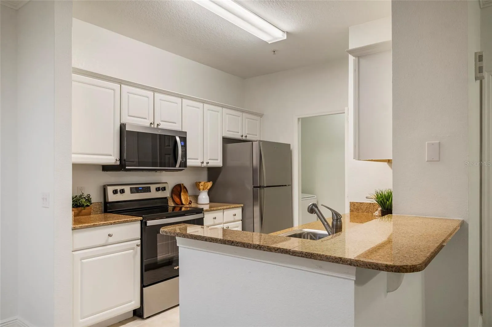 A total of 15 cabinet doors strategically planned to maximize storage, prep space and appliance location in the efficient triangle work space from Range to sink to refrigerator a well planned, minimum steps between work flow in this galley kitchen. The Laundry just a few steps away with its own dedicated space and door.