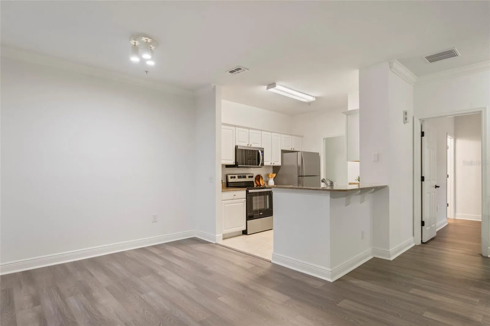From the dining area looking into the kitchen and laundry rooms. Note the overhang counter top with your own stools it makes a great place for a quick breakfast or after school snack.