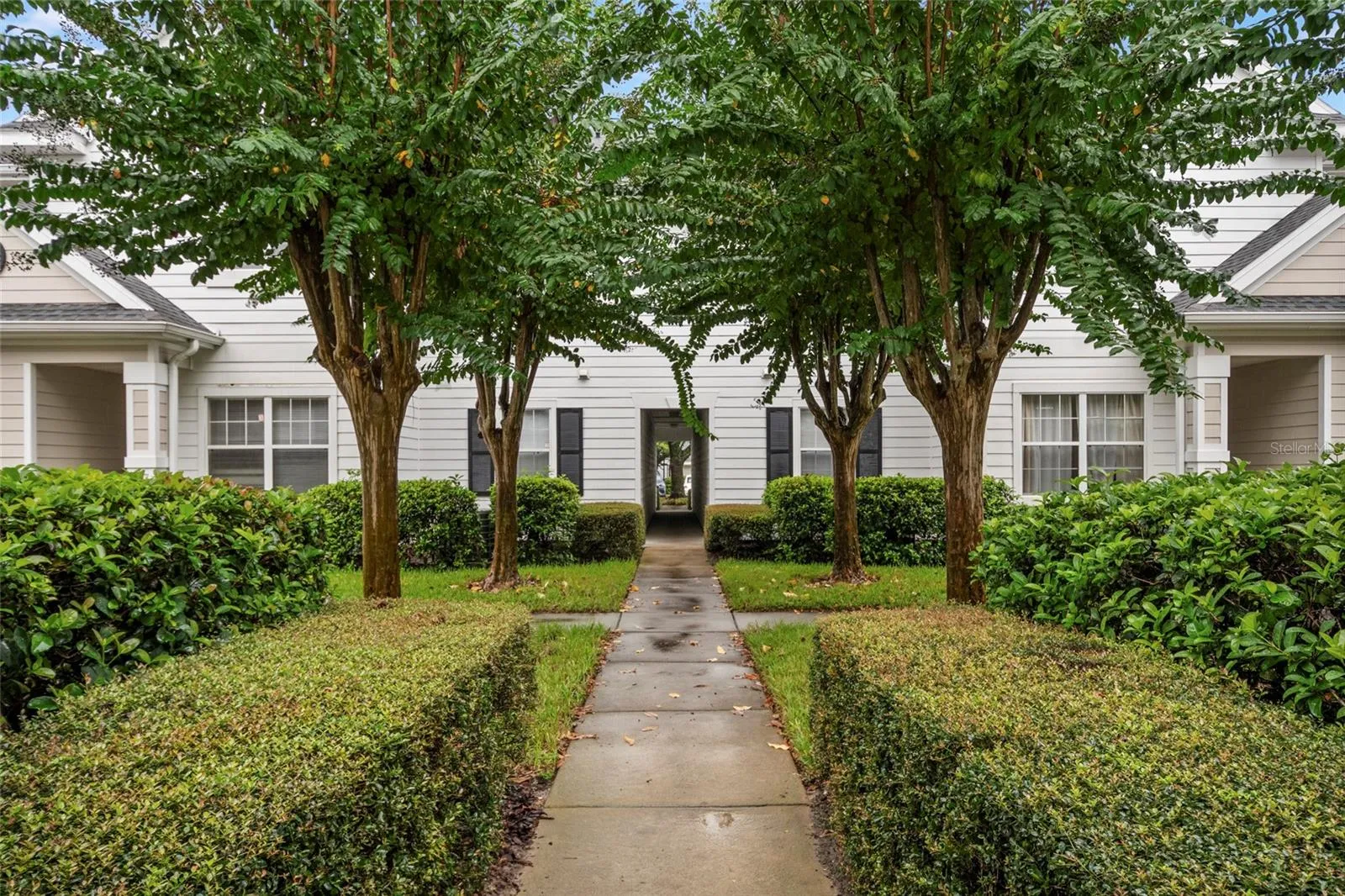 Well manicured mature landscaping greets you as you approach building 14, unit 208