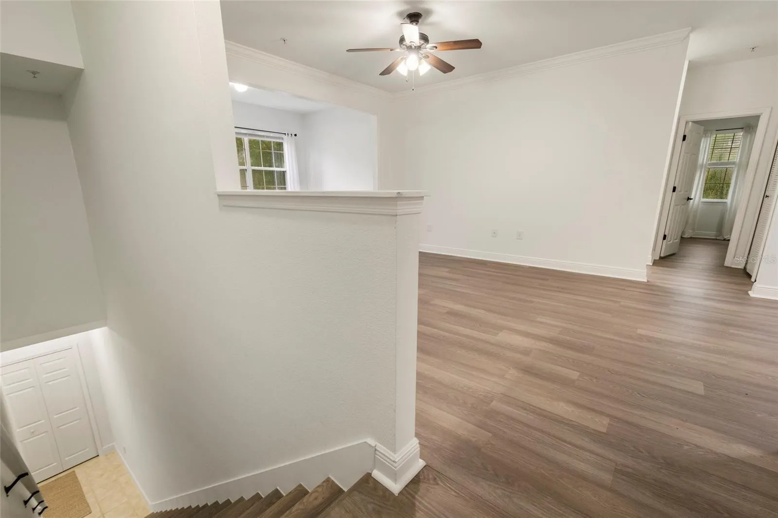 The view of the staircase with the steps finished in matching luxury plank vinyl. This lovely home has been updated with a clean, crisp transitional style.