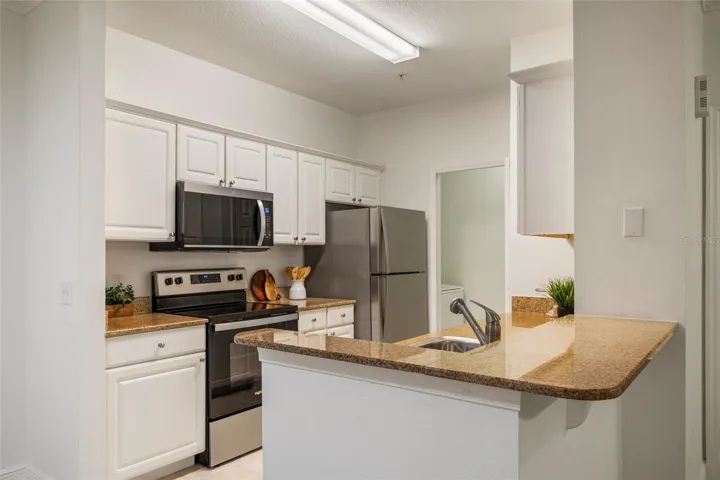 A total of 15 cabinet doors strategically planned to maximize storage, prep space and appliance location in the efficient triangle work space from Range to sink to refrigerator a well planned, minimum steps between work flow in this galley kitchen. The Laundry just a few steps away with its own dedicated space and door.