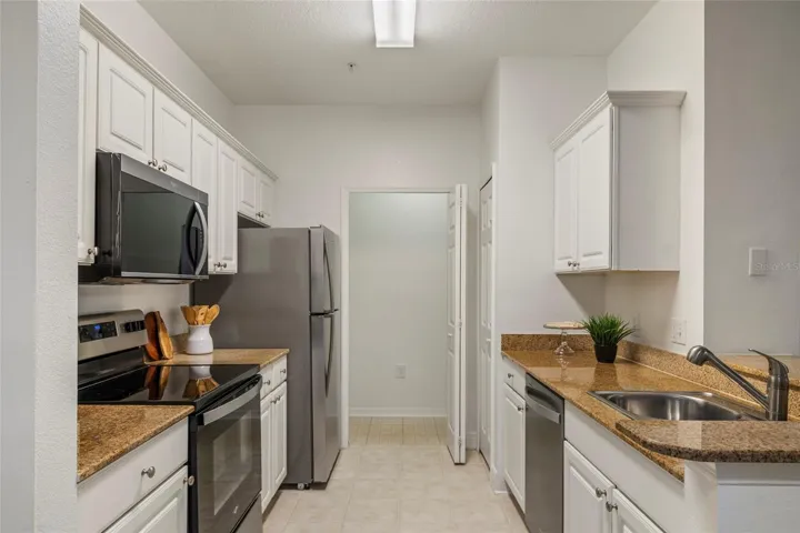 Direct view as you enter the galley kitchen and look to the far end which is the dedicated laundry room with bi fold door for days when that last load does not get done.