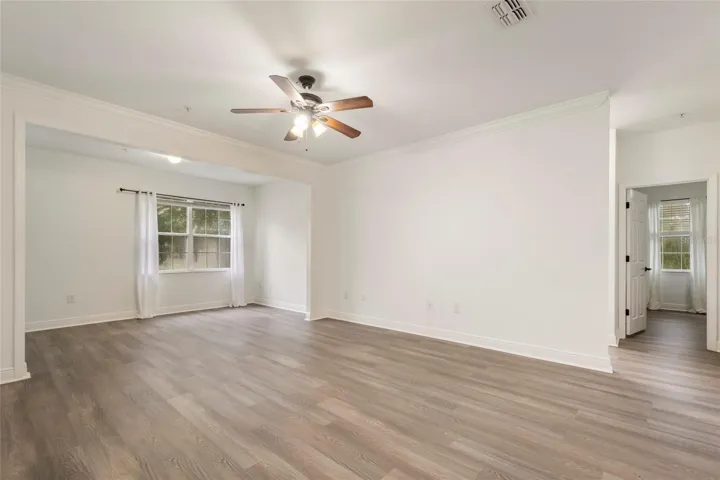A clear view of the supporting bedroom.  The family room also features a lighted ceiling fan, drapery rods( drapes do not convey) and a dedicated light in the alcove area.