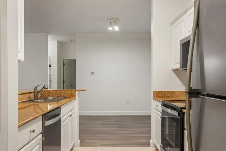 Along with the brand new microwave and refrigerator is a brand new dishwasher. These three appliances have never been used. The doors beyond are to supporting bedrooms.