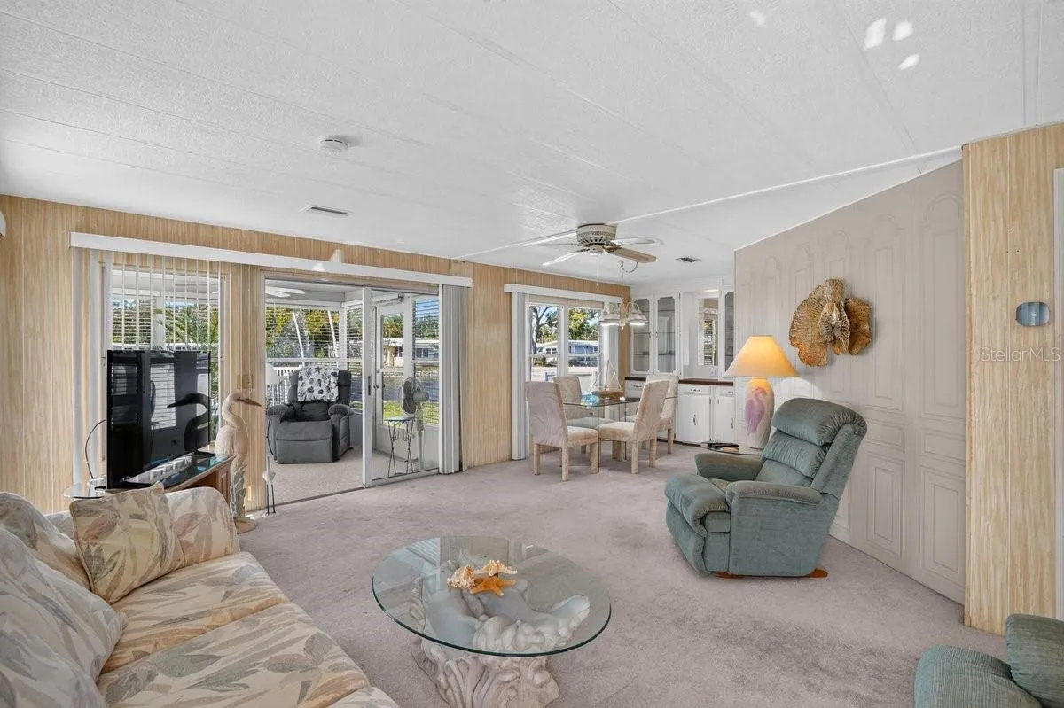Spacious Living Room Flows to Dining and Enclosed Porch * The Pool is Just Outside Your Door