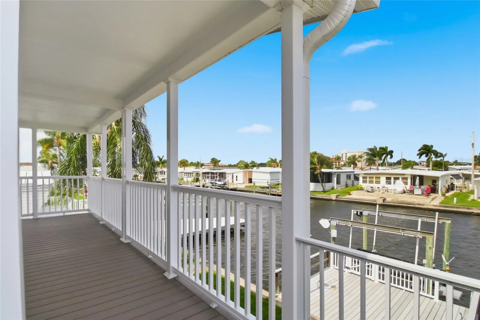 Expansive waterfront back patio overlooking large boat dock and lift