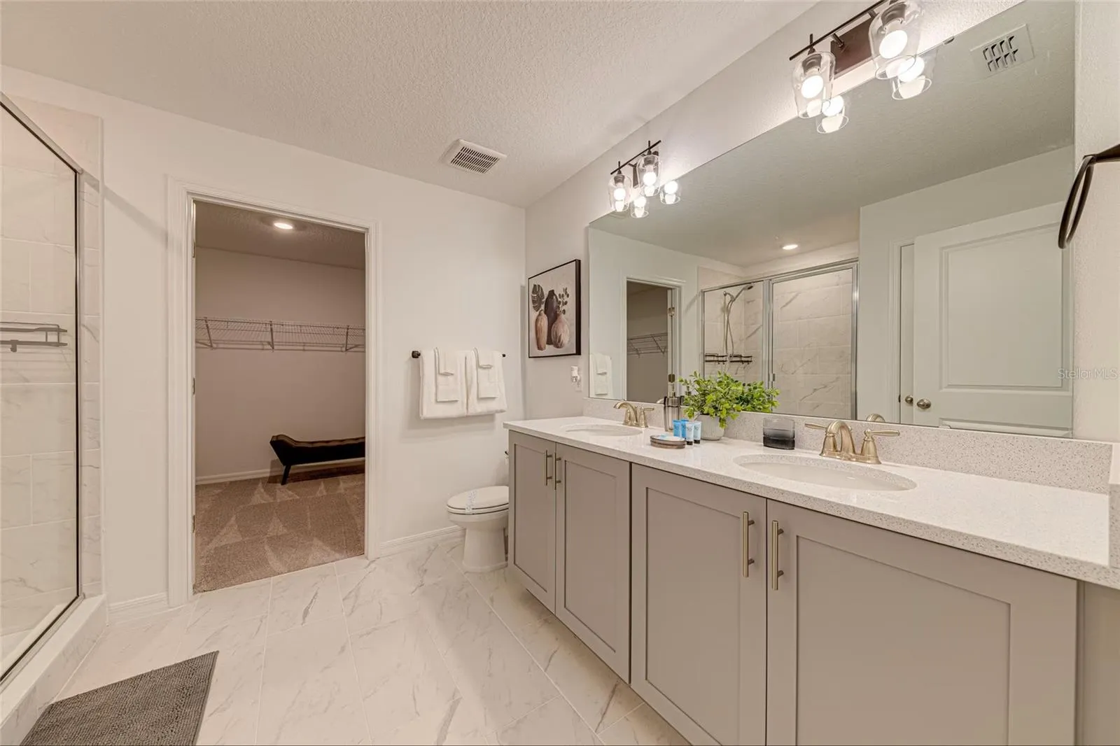 11. Primary Bathroom    Modern primary bathroom featuring a double vanity and spacious walk-in shower.