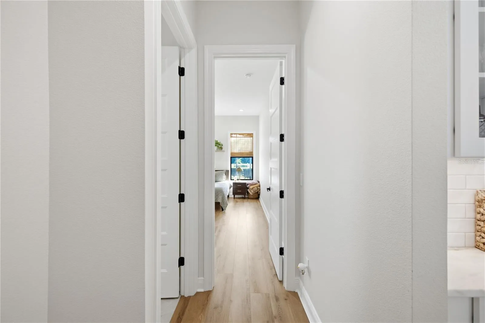 Hallway to primary suite with the laundry room conveniently located next to it.