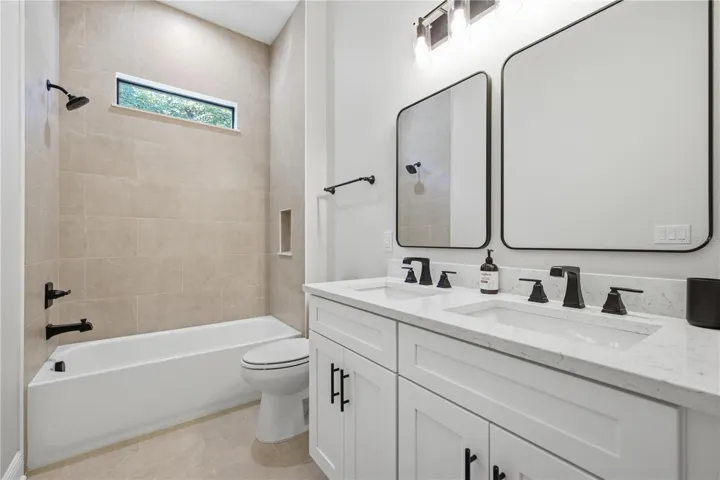 Full bathroom number three with tub/shower combo directly in between bedroom number three and four with dual sinks/vanity space and additional linen closet storage.