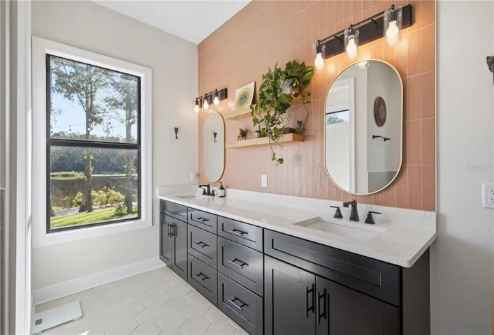 Ceramic tile backsplash all the way up the wall to ceiling in primary bathroom.