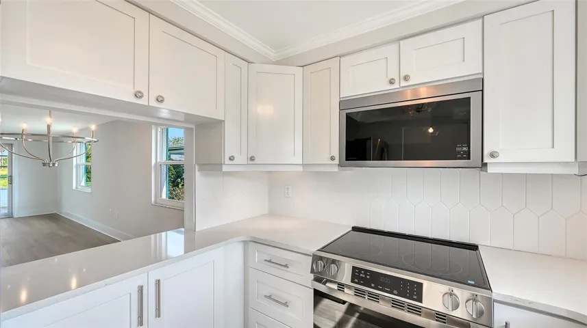 New Kitchen with stone countertops and stainless steel appliances. Pass through to Dining Room.