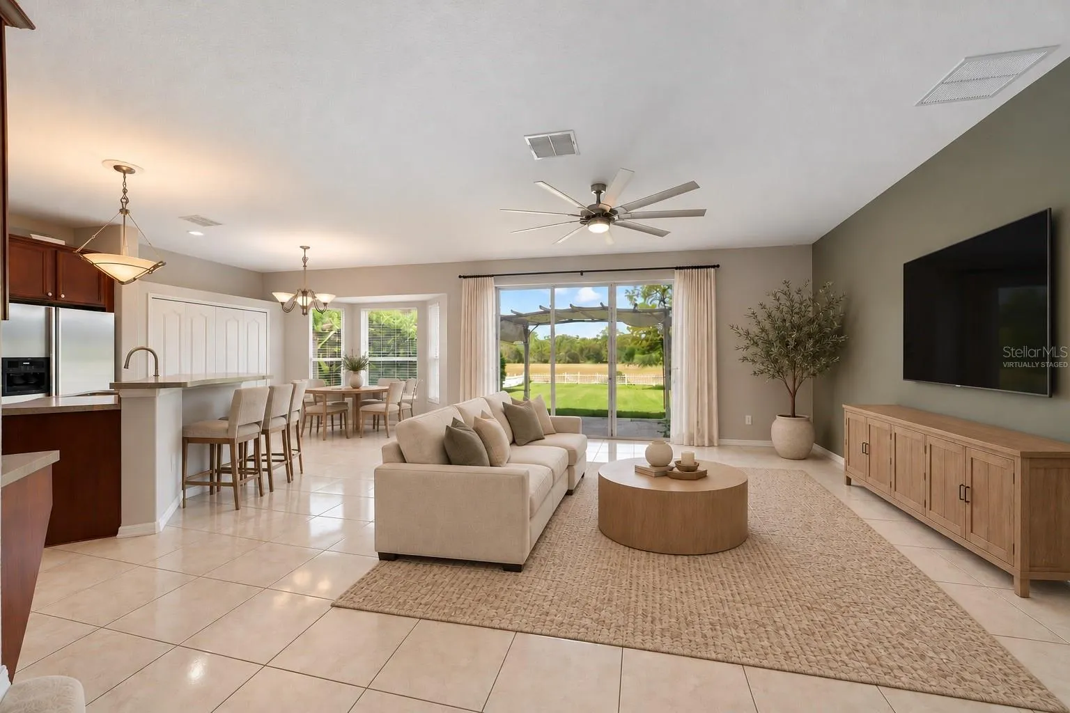 The Kitchen flows seamlessly into the Family Room, where triple sliding glass doors bring in NATURAL LIGHT and open to the back patio, extending the living space outdoors. Virtually Staged