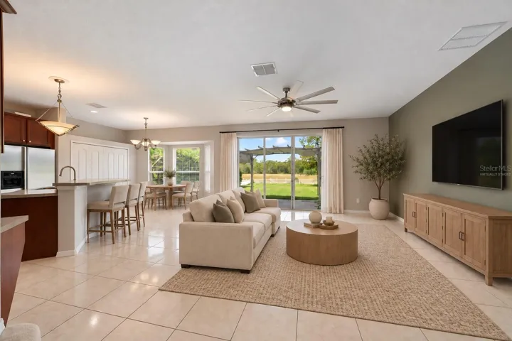 The Kitchen flows seamlessly into the Family Room, where triple sliding glass doors bring in NATURAL LIGHT and open to the back patio, extending the living space outdoors. Virtually Staged