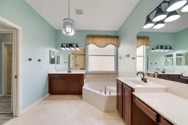 The Primary en suite Bath features dual vanities, a RELAXING GARDEN TUB, a step-in shower and a private water closet.