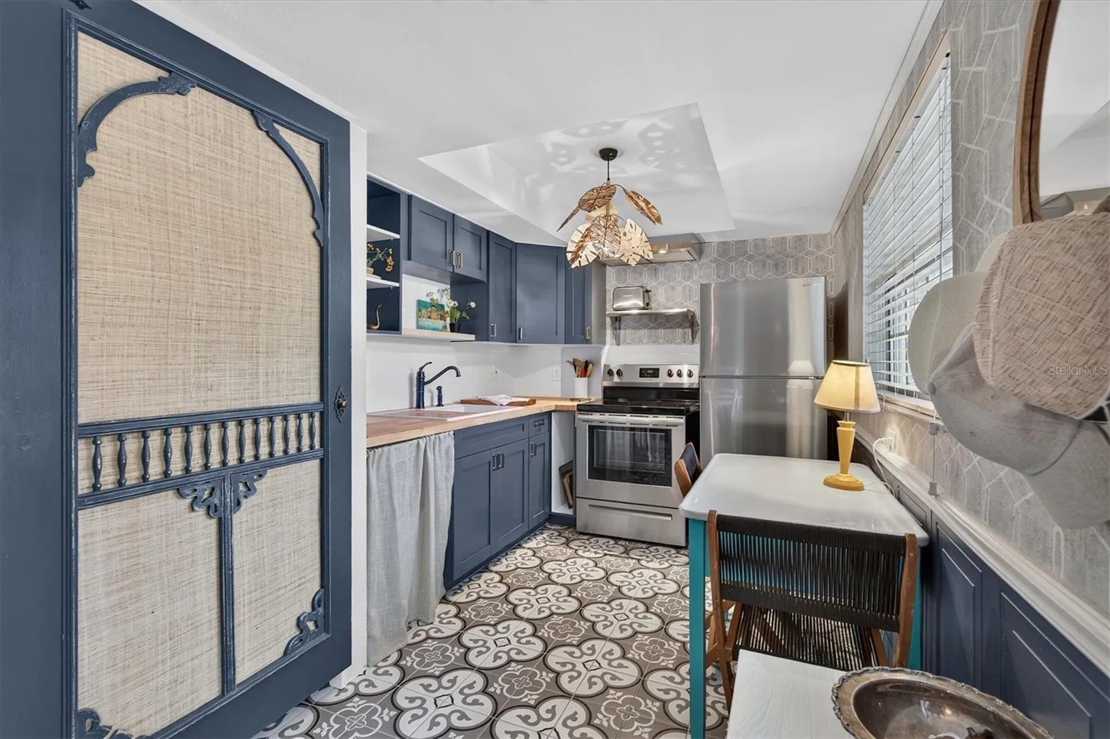 Moorish patterned ceramic tile and unique coastal chandelier in kitchen.