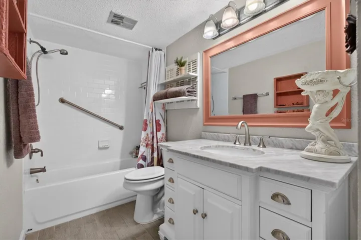 Modern bath with tub, shower, large vanity and linen closet.