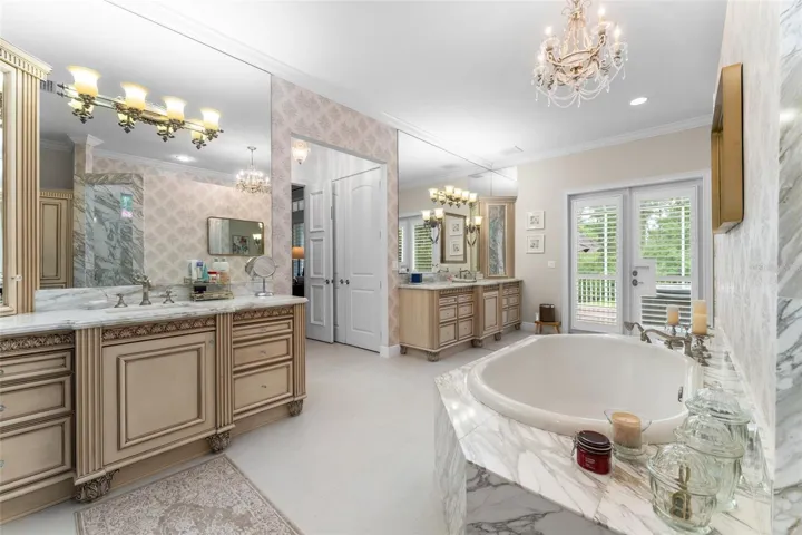 Master bath with dual vanities and door leading to private screened porch