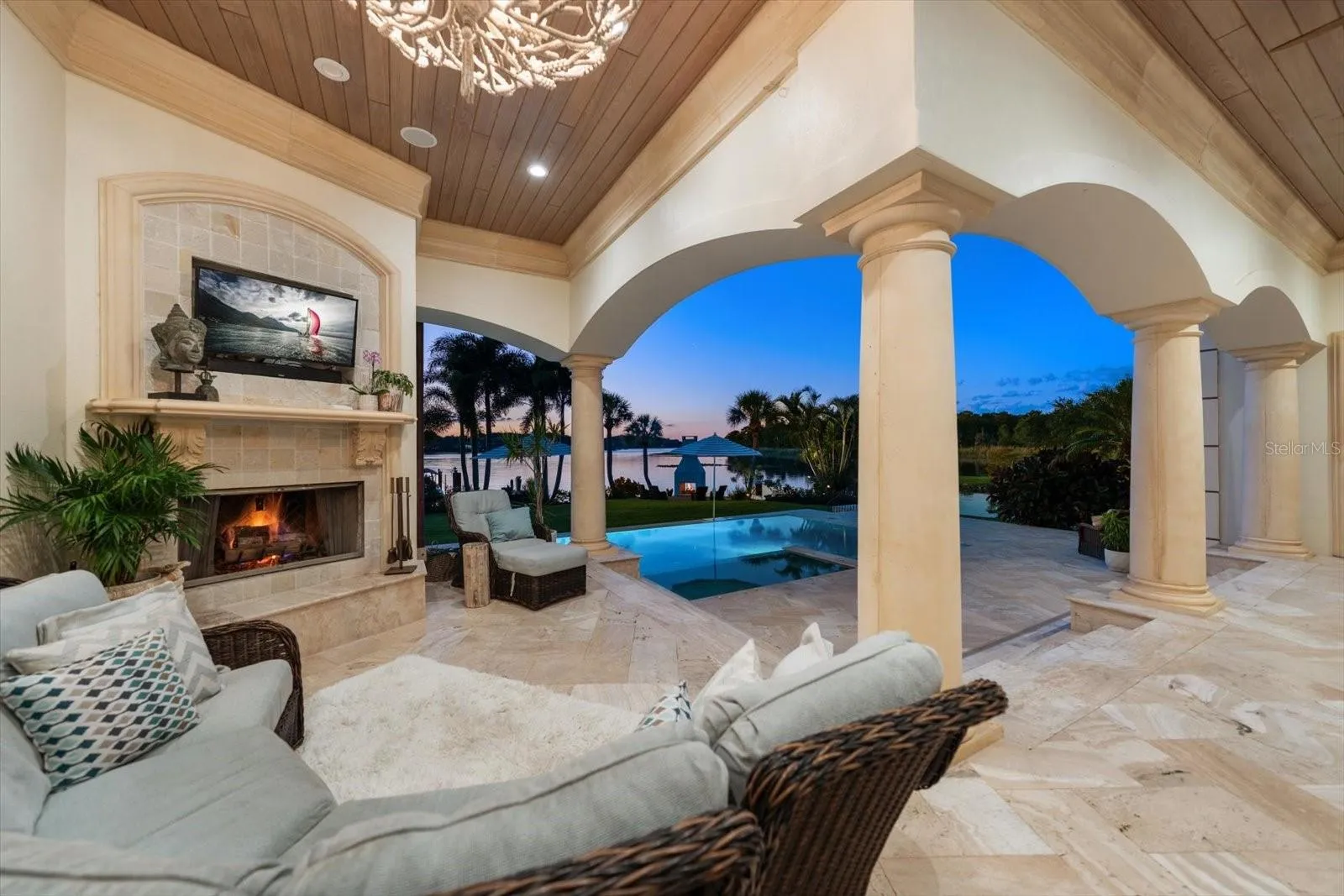 An expansive covered lanai offers inviting seating, a wood-and-gas fireplace and an Alfresco outdoor kitchen