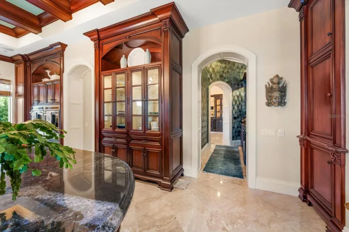 Arched doorways and a walk-through wet bar connecting to the formal dining room