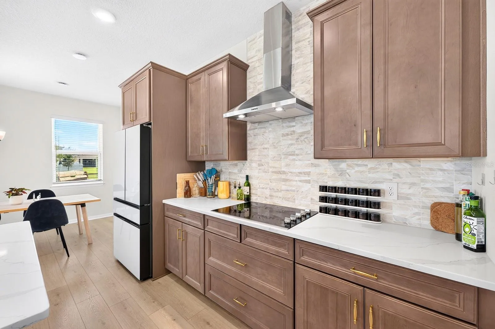 The Kitchen features solid wood cabinetry, QUARTZ COUNTERTOPS, a stylish modern backsplash and a convenient closet pantry.