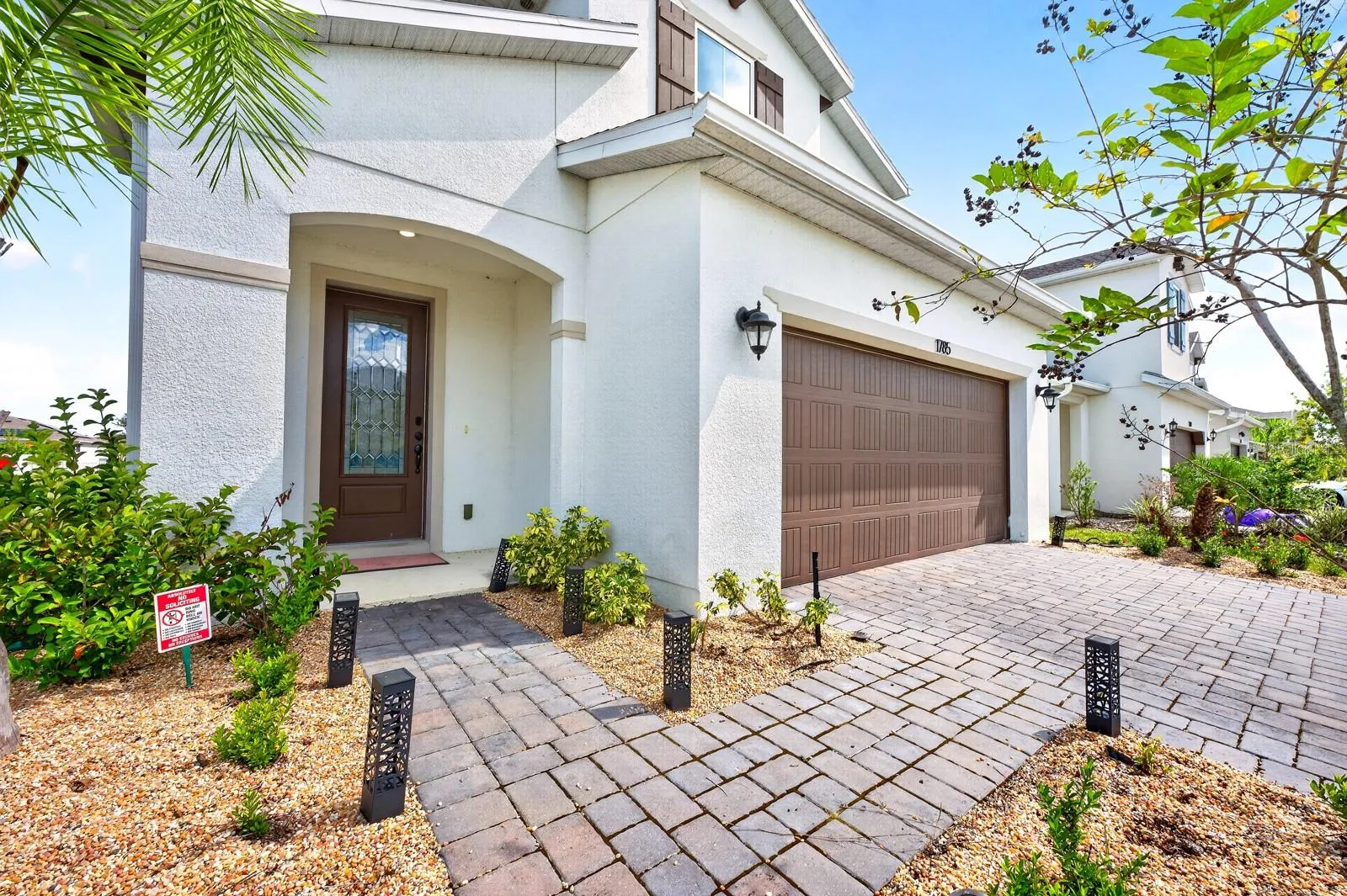 A BRICK PAVER DRIVEWAY leads to the TWO-CAR GARAGE, while a matching paver walkway welcomes you to the front porch.