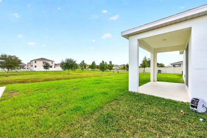 Step outside to the COVERED REAR PORCH overlooking the GENEROUS BACKYARD.