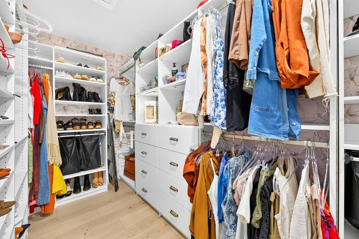 The generous walk-in closet is enhanced by a CUSTOM BUILT-IN CLOSET SYSTEM (2025), creating an organized and functional space.