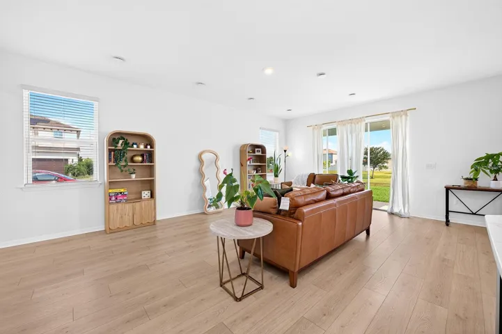 NATURAL LIGHT pours in through the windows and sliding glass door, enhancing the home's warm, airy feel.