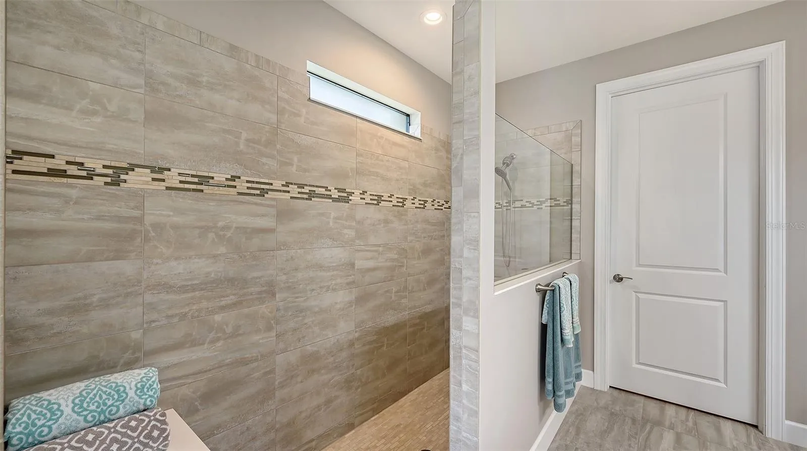 The primary bath offers a spa-inspired retreat, featuring an oversized walk-in shower designed for relaxation and rejuvenation.