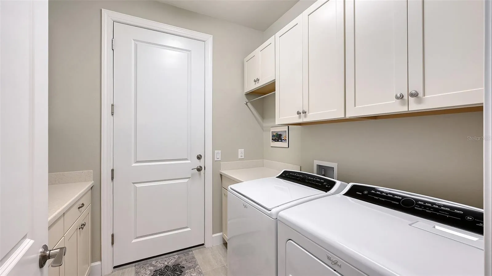 This exceptional laundry room has built-in cabinets on both side of the room for additional storage for your convenience.