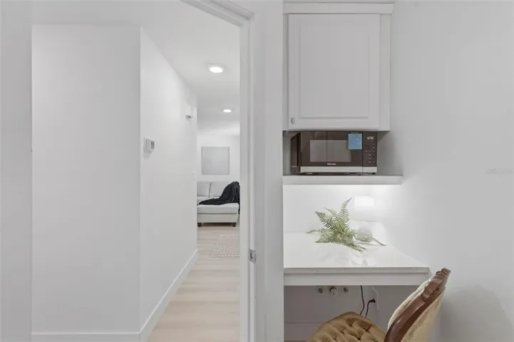 Desk area in laundry room with microwave, air fryer combo. storage