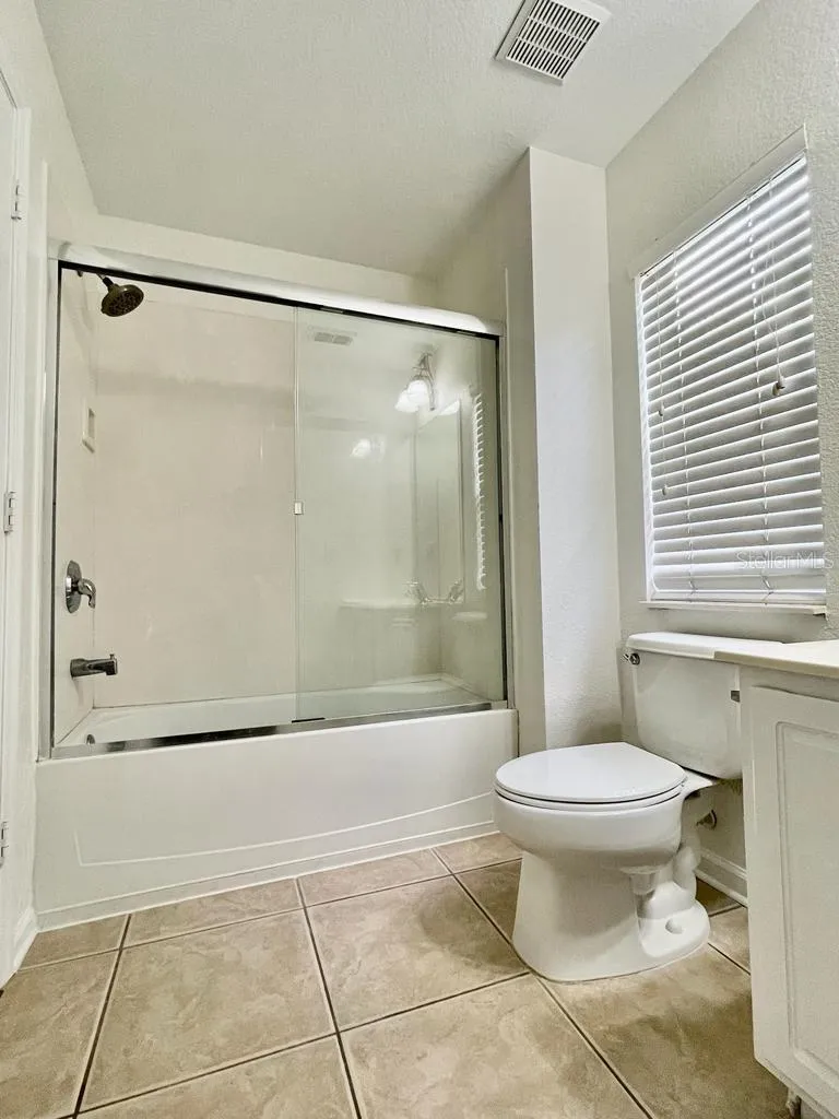 bath with tub/shower and glass enclosure.