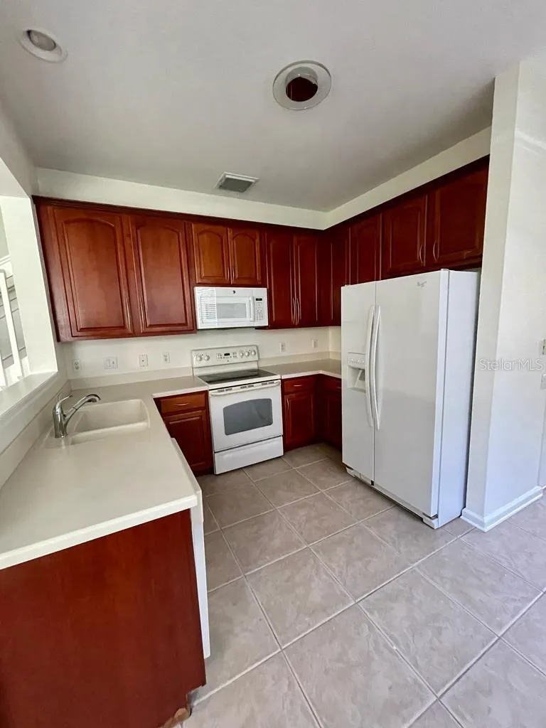 Functional kitchen with rich wood cabinetry and generous counter space.