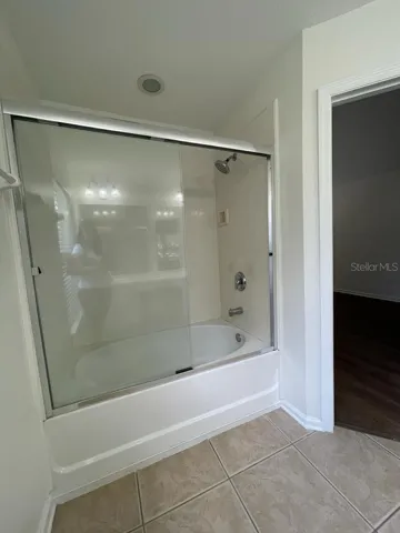 Primary bath with tub/shower and glass enclosure.