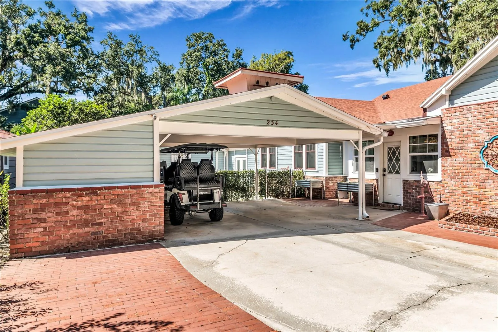 Double Carport includes both a Tesla and golf cart charging station as well as a large storage closet equipped with power and a shop desk.