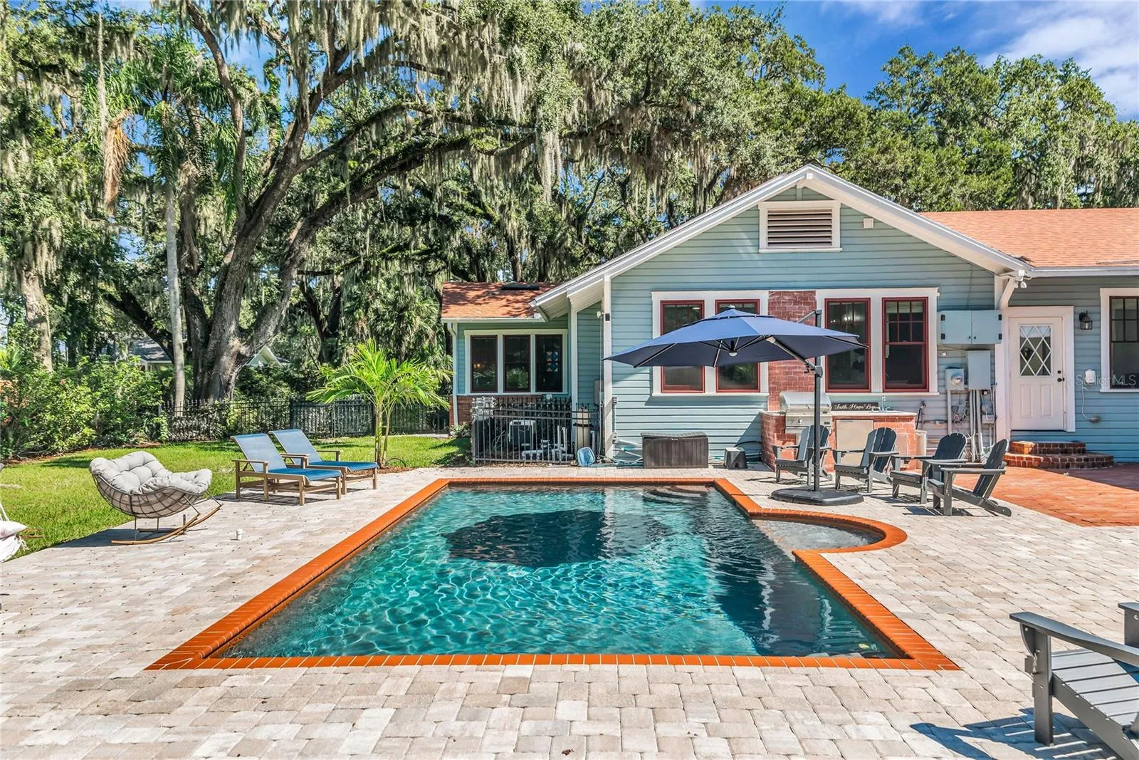 The enormous fully fenced backyard is designed for year-round enjoyment with a gas-heated saltwater sport pool, outdoor kitchen, expansive brick paved deck, detached covered lanai, and low-maintenance turf.