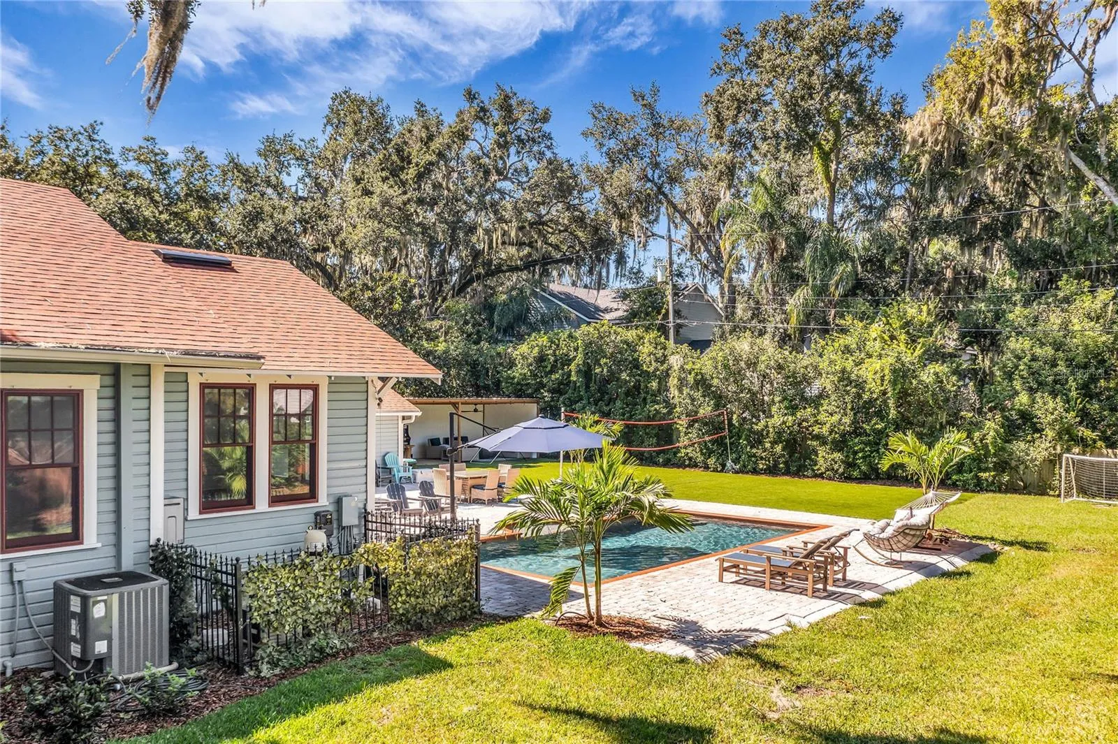 The enormous fully fenced backyard is designed for year-round enjoyment with a gas-heated saltwater sport pool, outdoor kitchen, expansive brick paved deck, detached covered lanai, and low-maintenance turf.